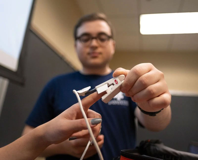 Jonny Turovsky gives a demonstration of a pulse oximeter for measuring blood oxygen saturation during the Lafayette University EMS Team's final meeting of the school year on Tuesday night at the college campus in Easton. (SHARON K. MERKEL / Special to The Morning Call)